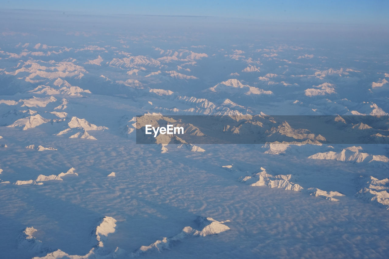 AERIAL VIEW OF SNOWCAPPED LANDSCAPE AGAINST SKY