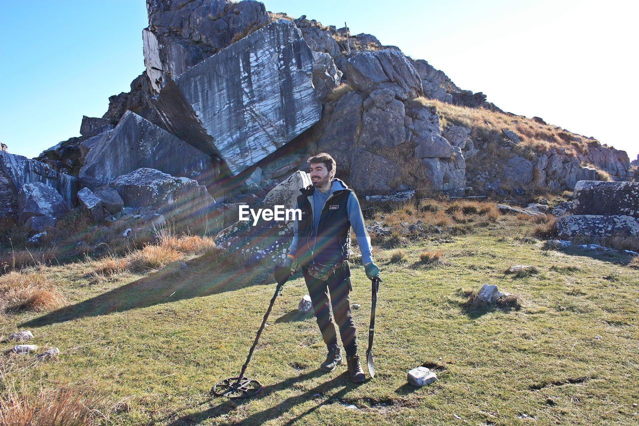 MAN STANDING ON ROCK BY ROAD