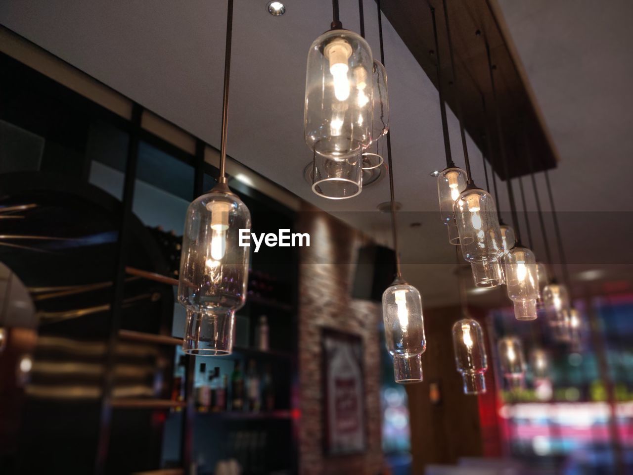 Low angle view of illuminated pendant lights hanging from ceiling in restaurant