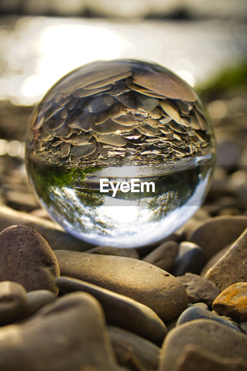 CLOSE-UP OF CRYSTAL BALL ON STONE