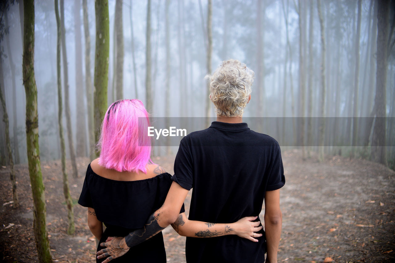 Rear view of couple standing in forest