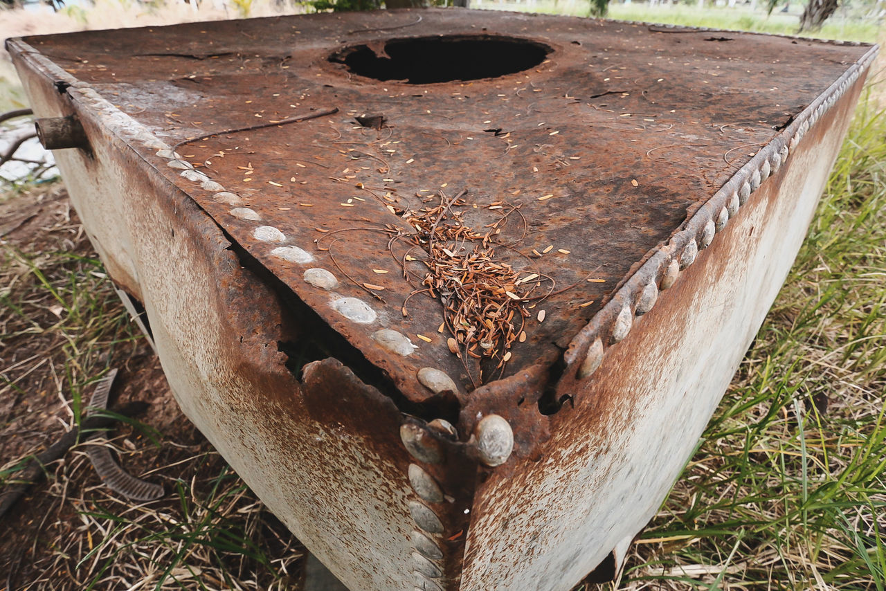 HIGH ANGLE VIEW OF RUSTY METAL ON WOOD