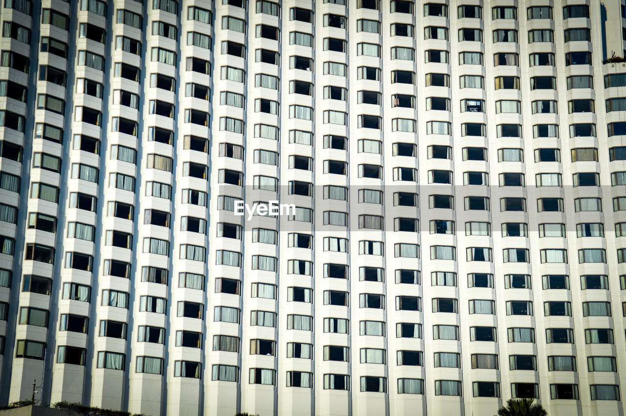 Low angle view of office building windows in bangkok city