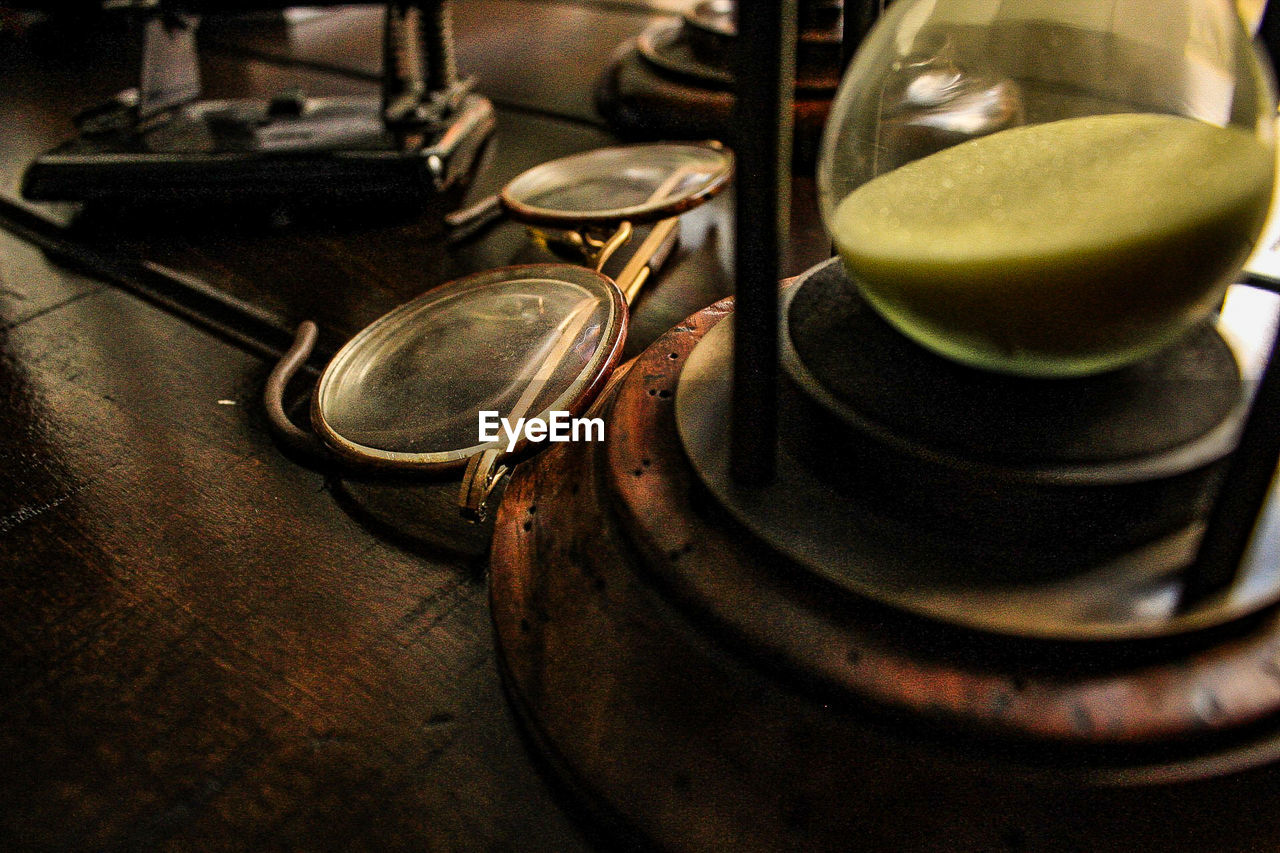 High angle view of eyeglasses by hourglass on table