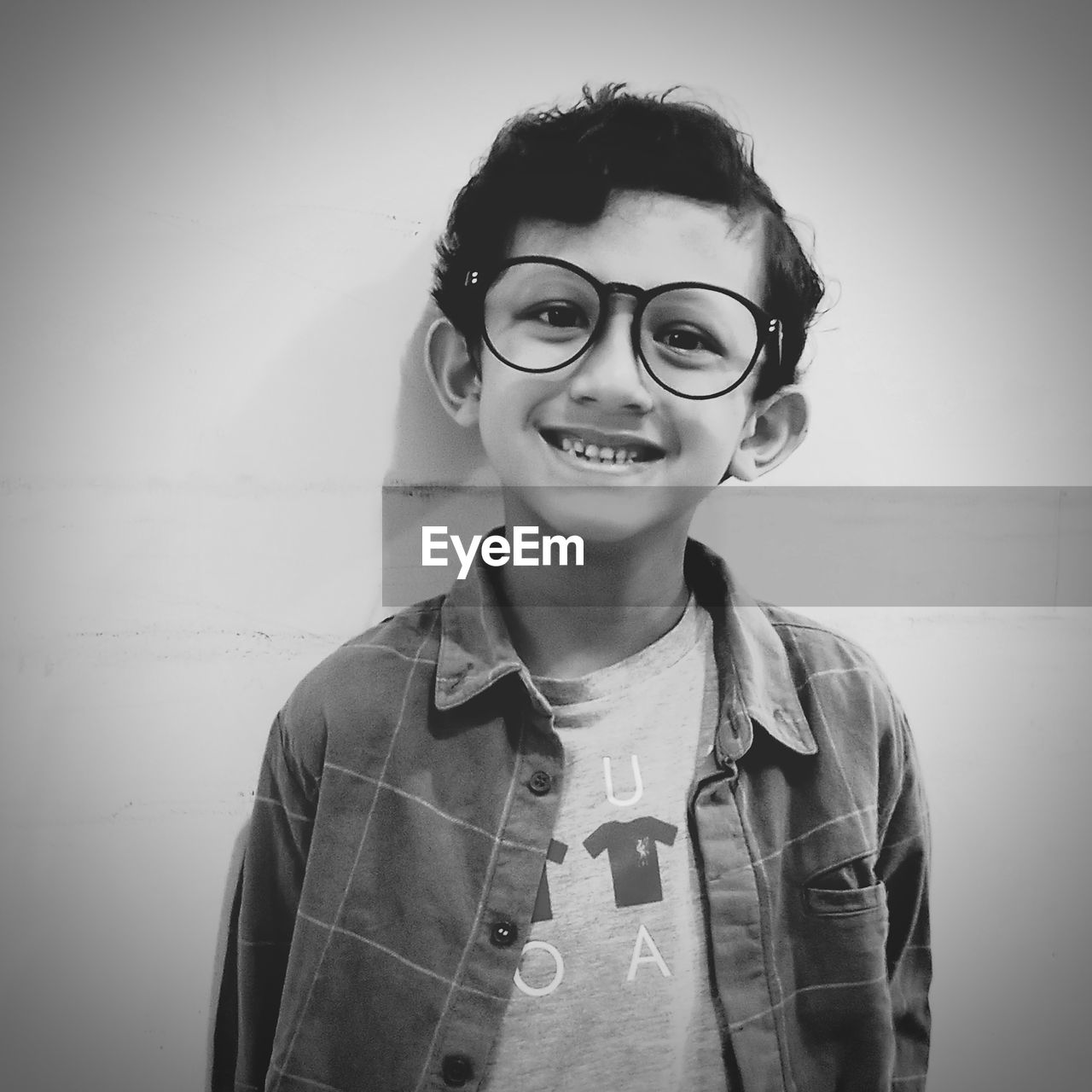 Monochrome portrait of young boys smiling wearing glasses