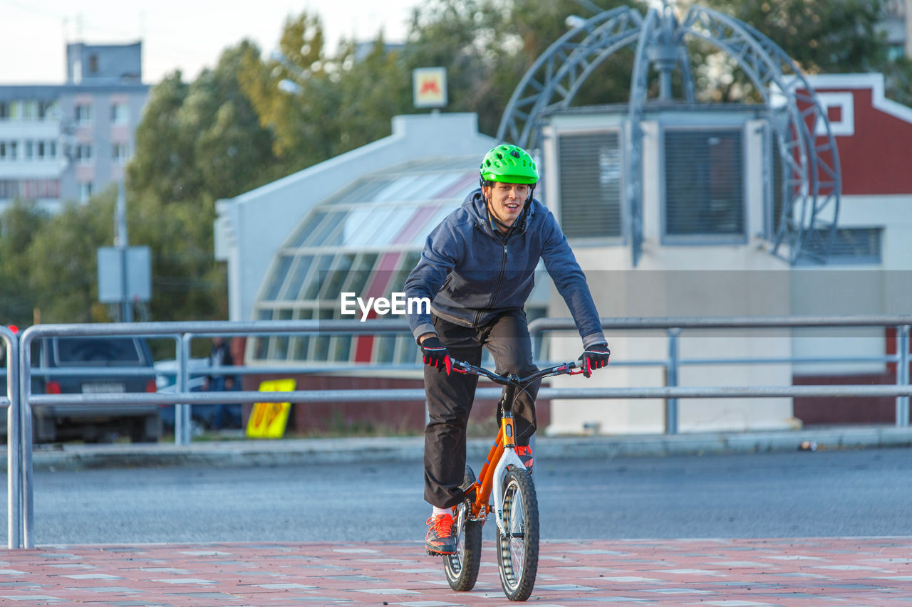 MAN RIDING BICYCLE ON ROAD