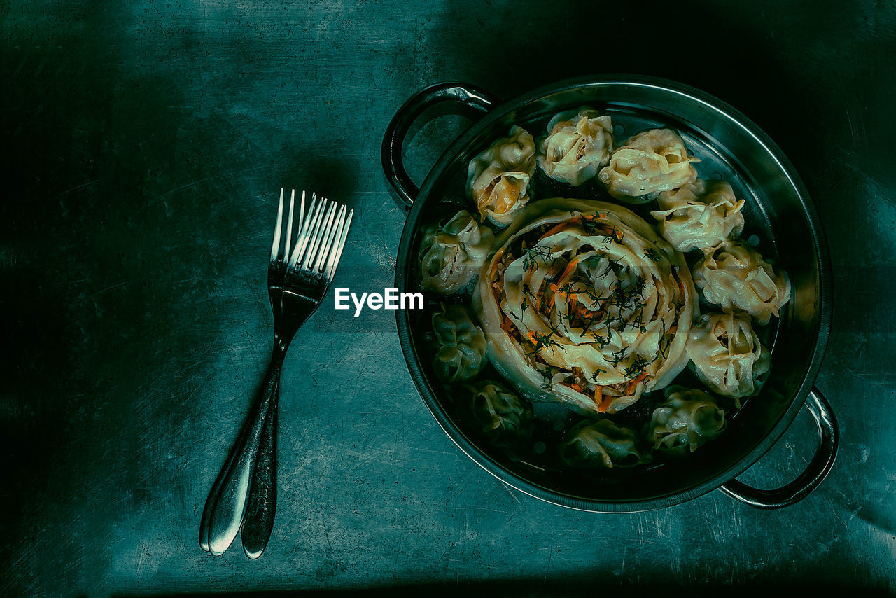 High angle view of  khonim - xonim uzbek food on a metal steaming pan and forks for eating