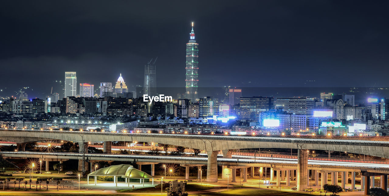 Illuminated city against sky at night