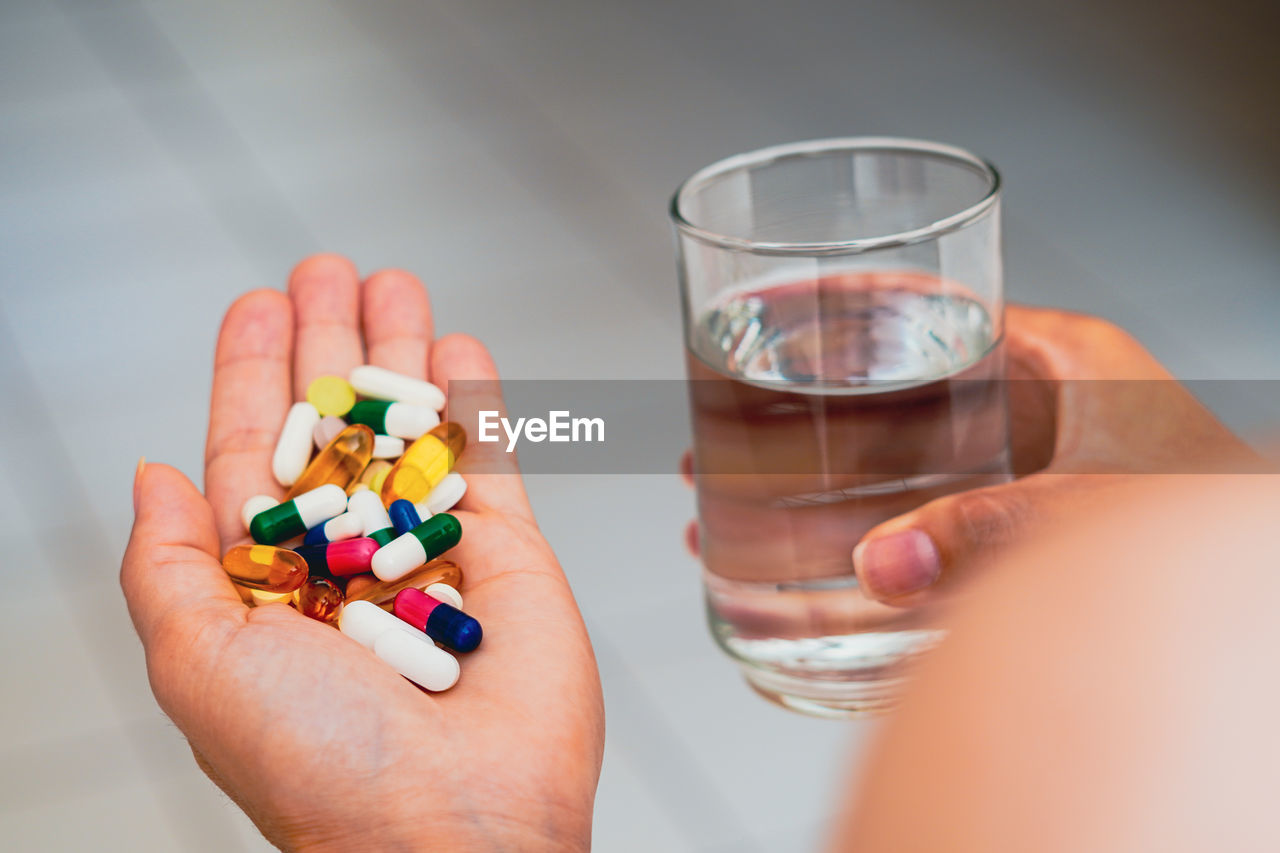 cropped hand of woman holding pills