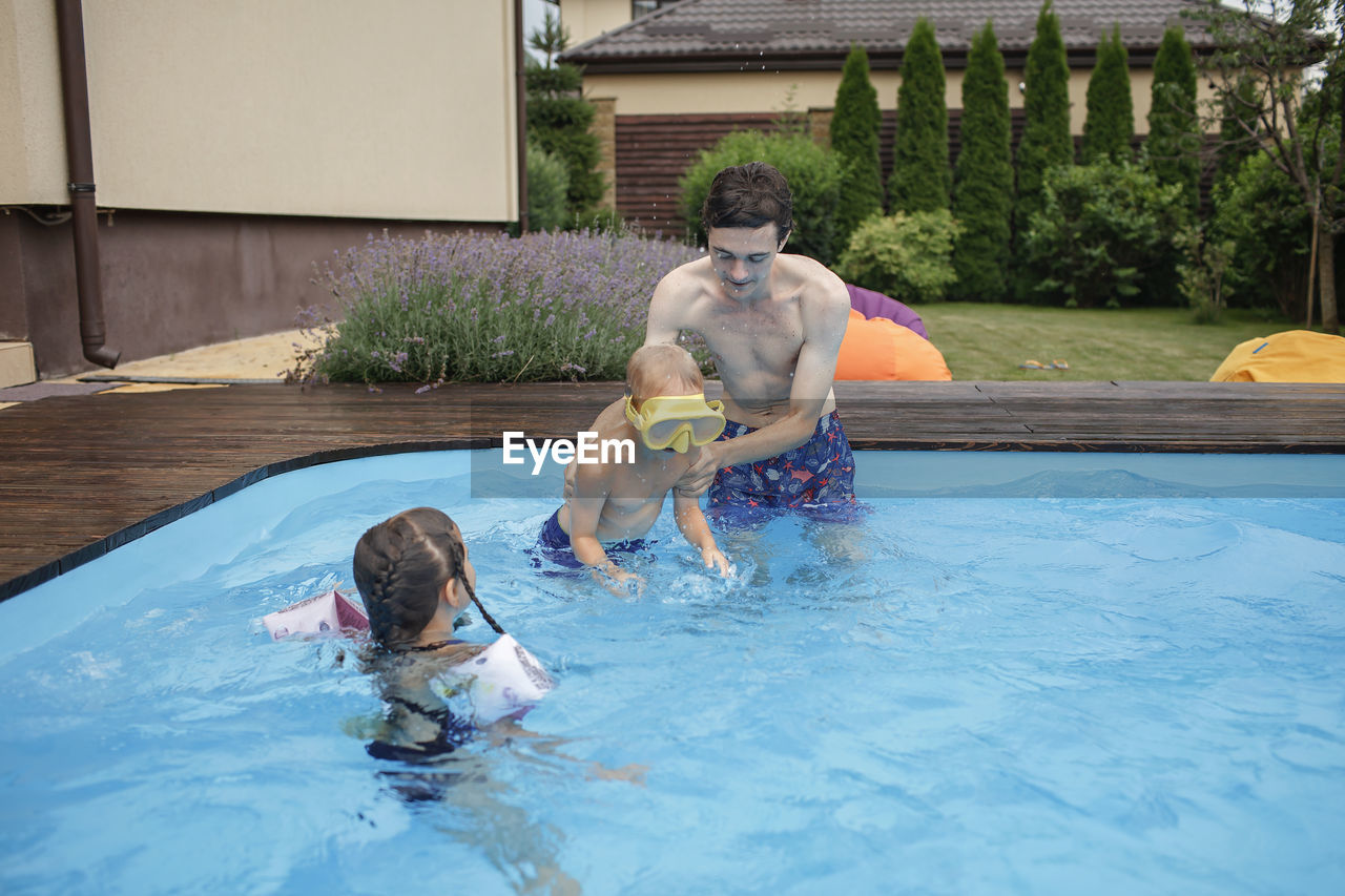 Full length of father and daughter in swimming pool