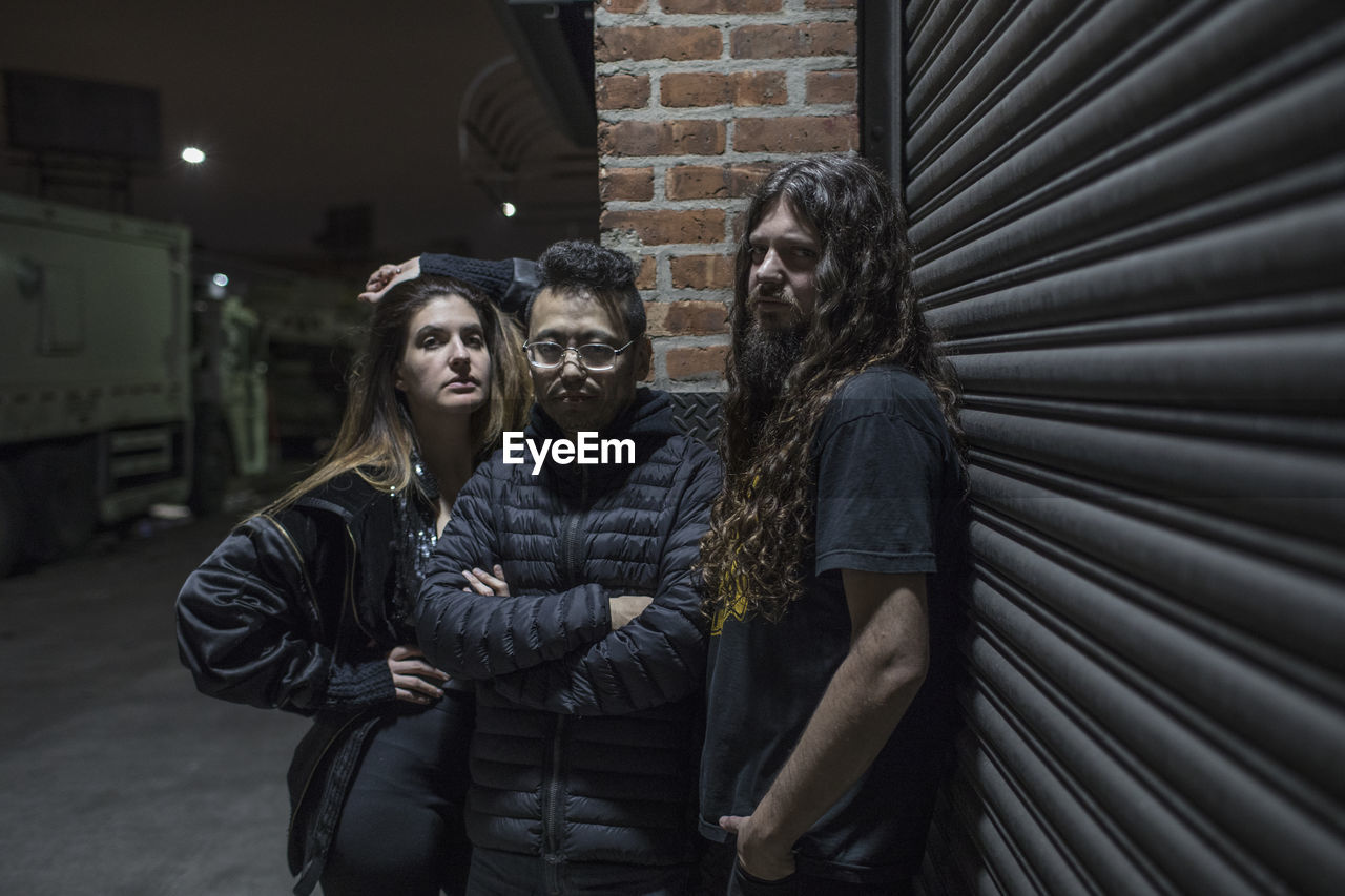 Band posing for portrait on a street at night