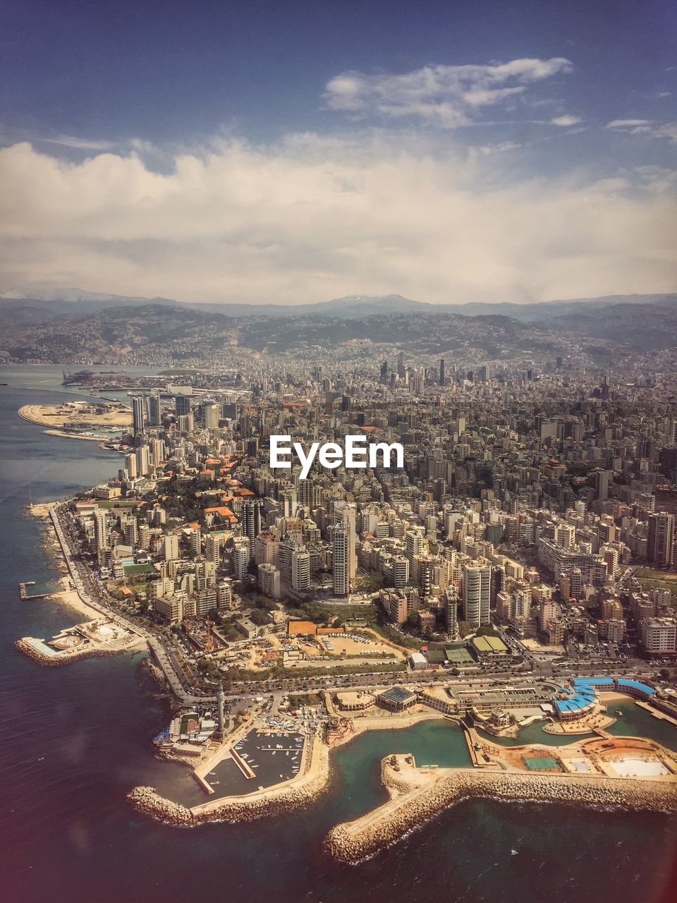 High angle view of cityscape by sea against sky