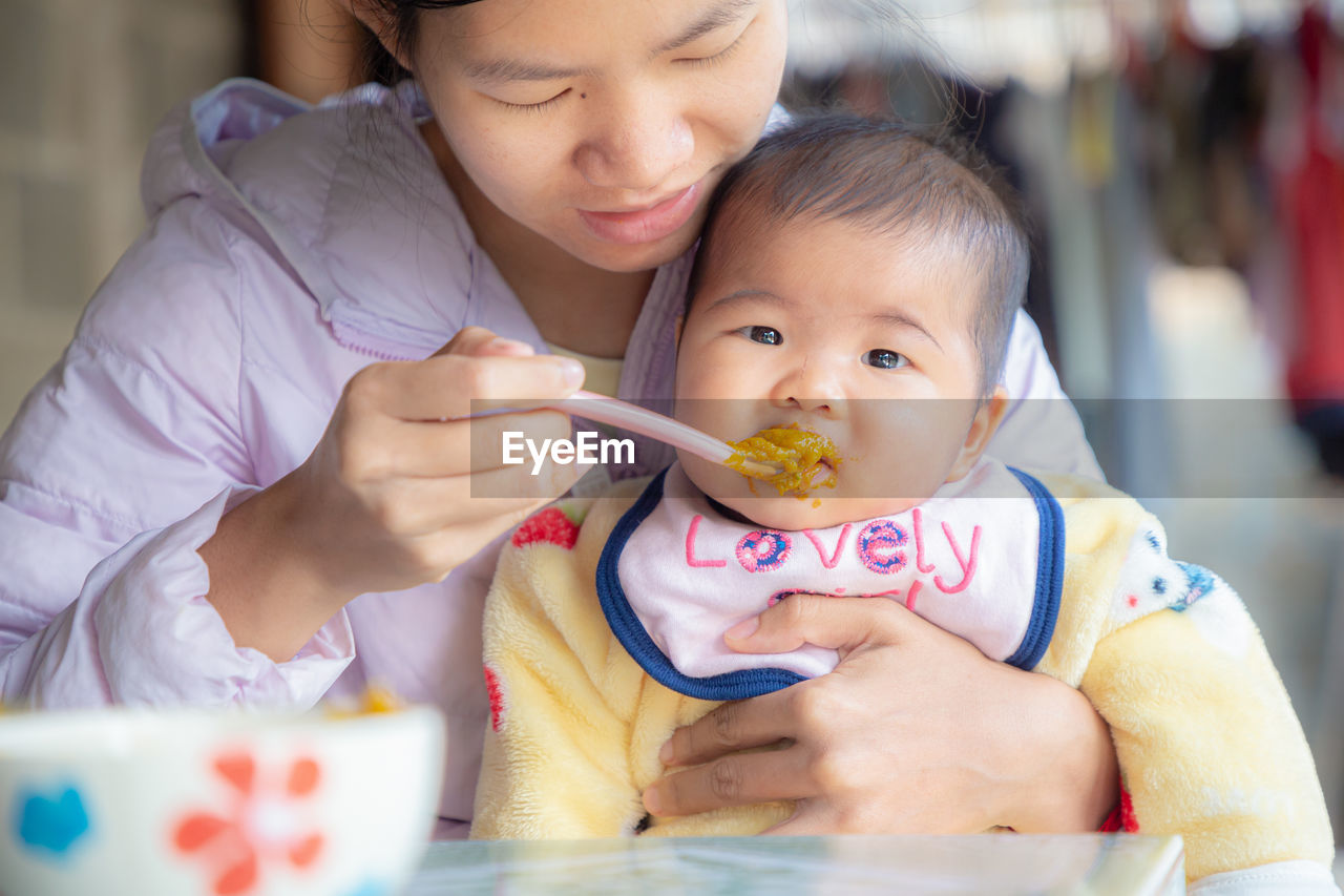 Close-up of mother feeding baby