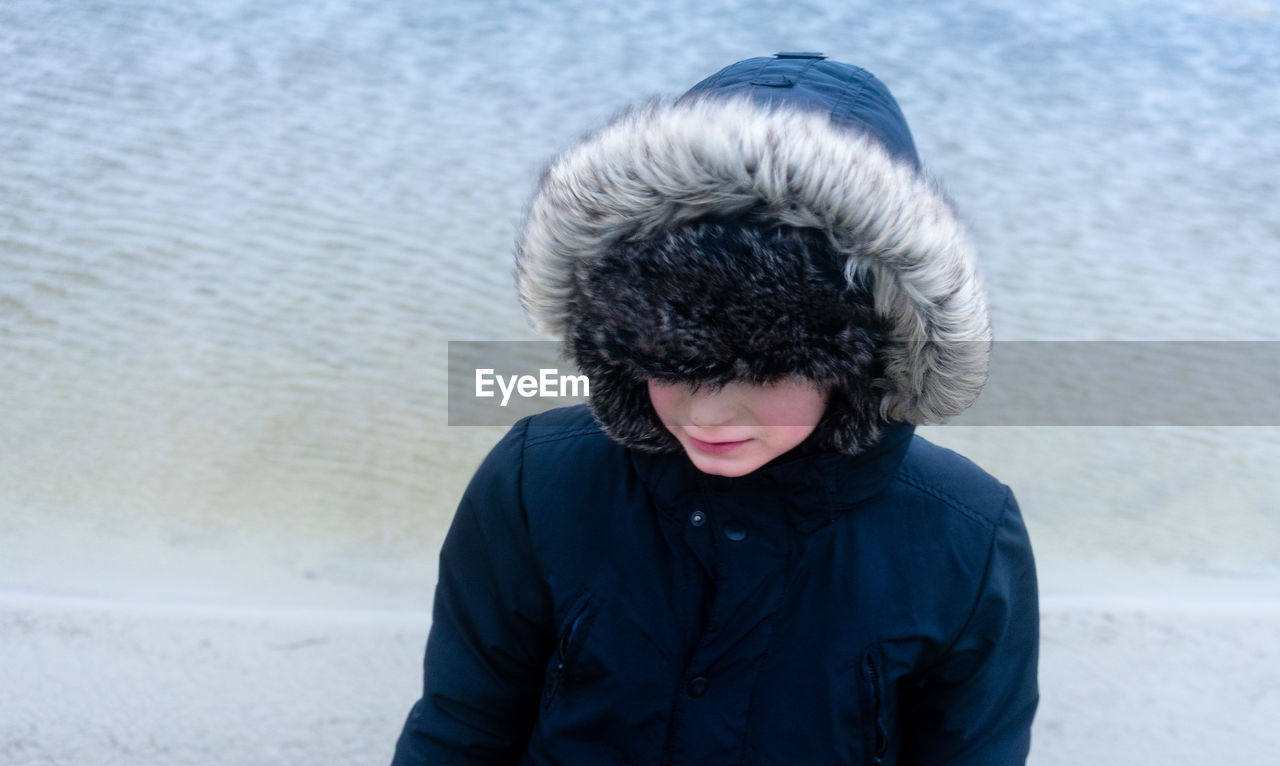 High angle view of woman wearing fur coat at beach during winter