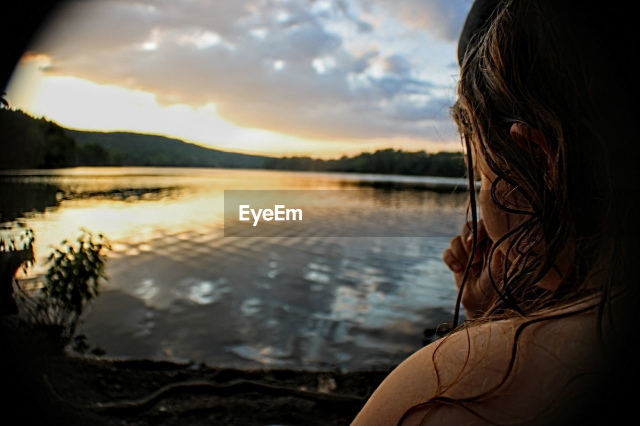 PORTRAIT OF WOMAN IN LAKE AGAINST SKY