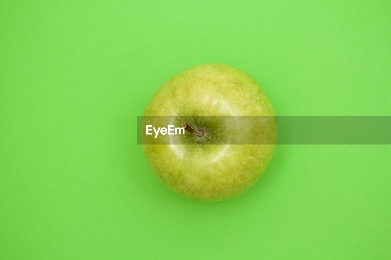 Close-up of apple on green background