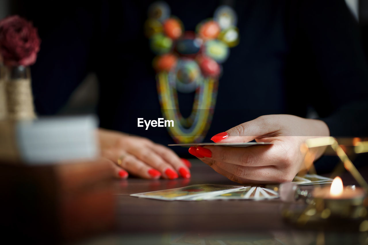 midsection of woman using mobile phone on table in office