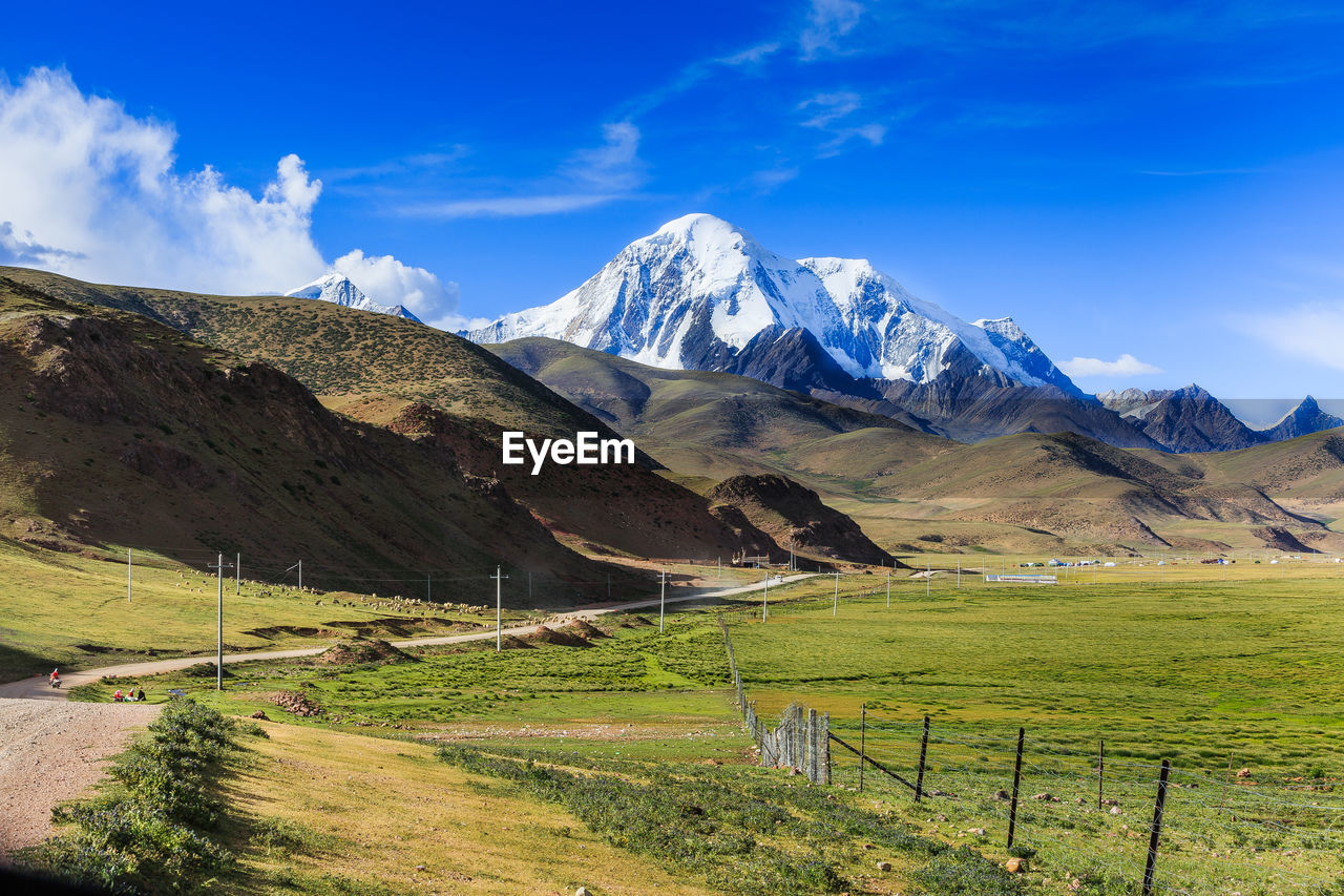 Scenic view of mountains and field against sky