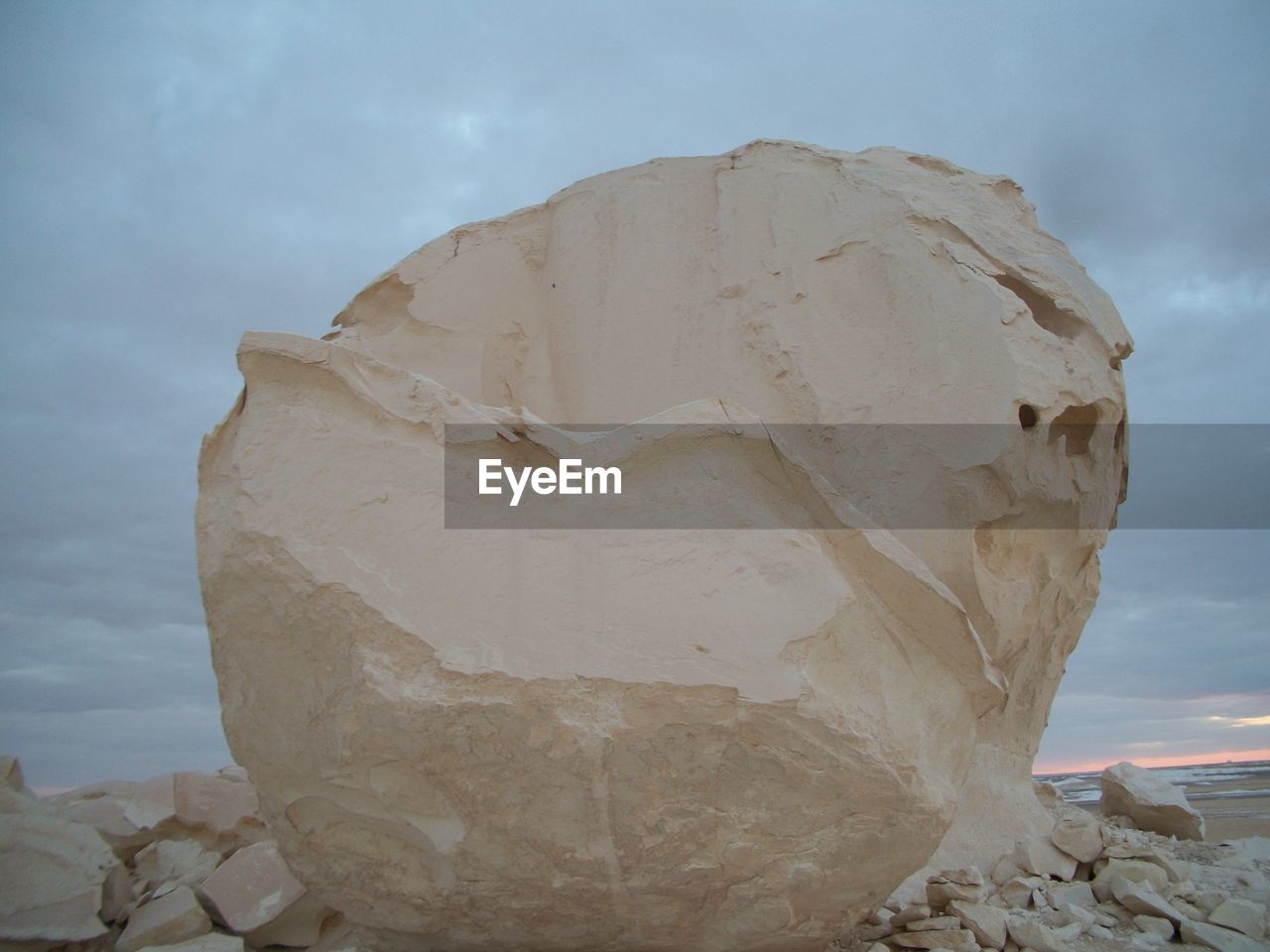 CLOSE-UP OF ROCK FORMATION AGAINST CLOUDY SKY