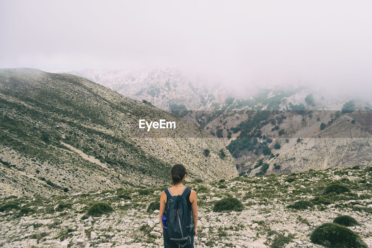 Woman hiking on a mountain path in catalonia on a cloudy summer day