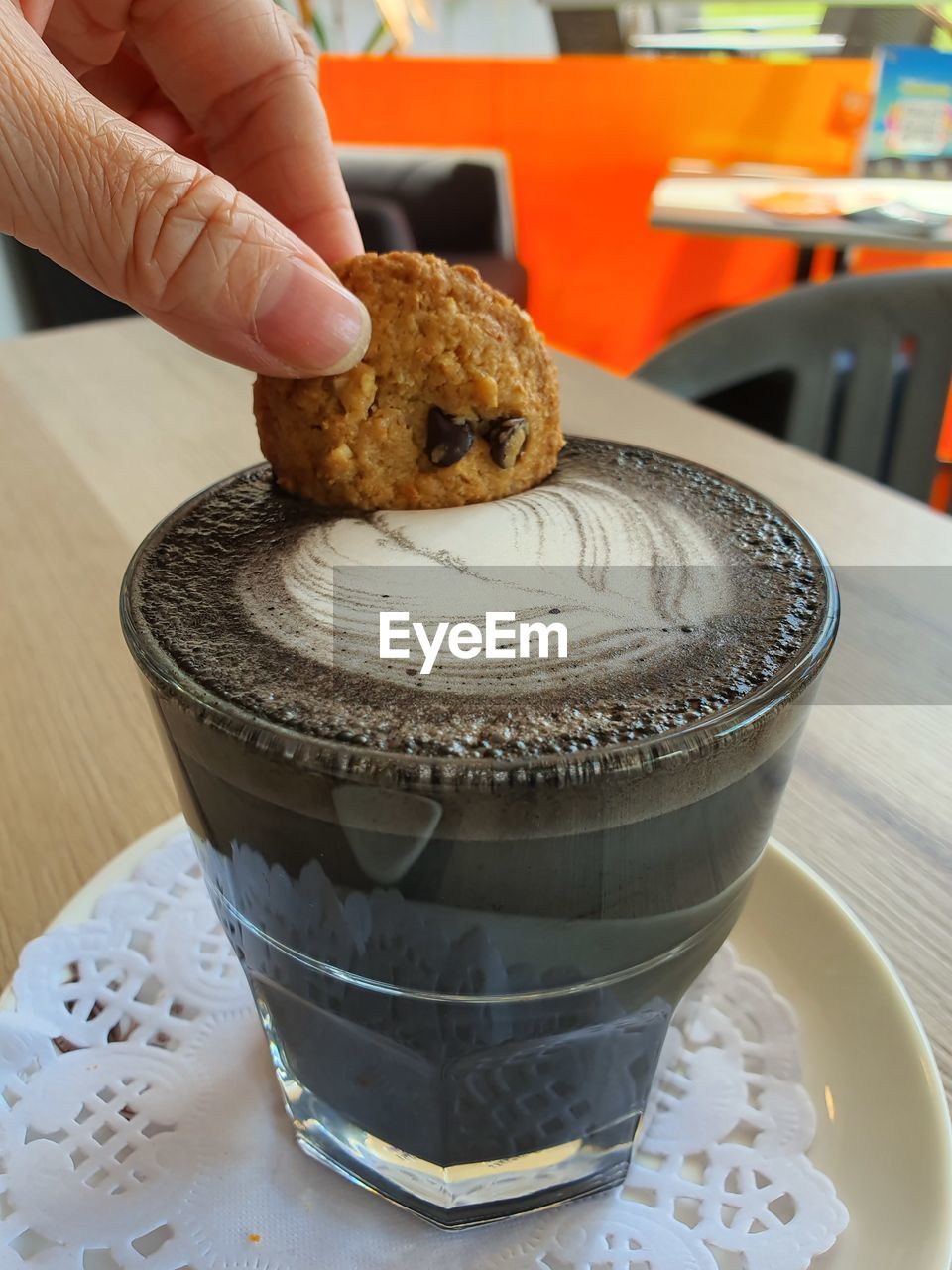 CLOSE-UP OF HAND HOLDING ICE CREAM WITH SPOON