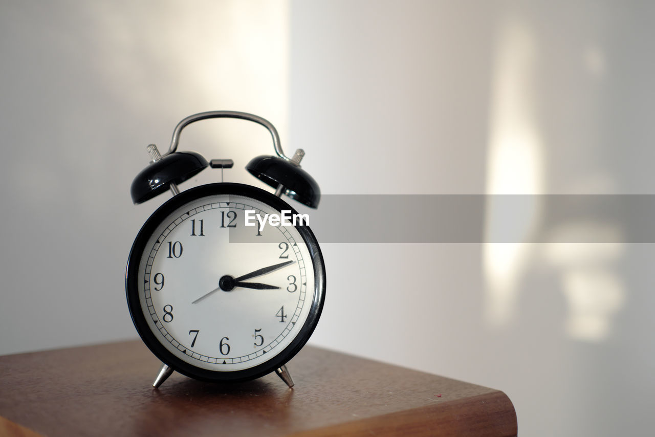 Alarm clock on a shelf at home in afternoon light - time keeping concept