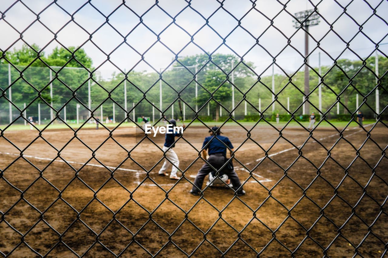 People playing seen through chainlink fence