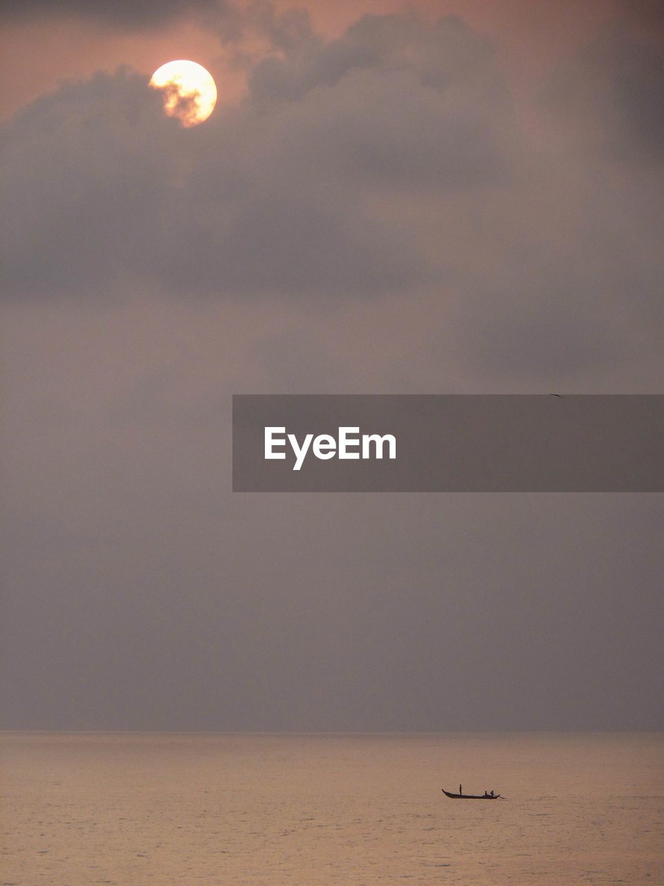 View of boat on calm sea at sunset