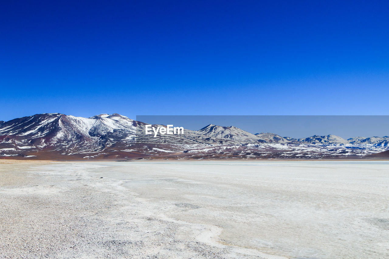 SCENIC VIEW OF SNOWCAPPED MOUNTAINS AGAINST CLEAR BLUE SKY DURING WINTER