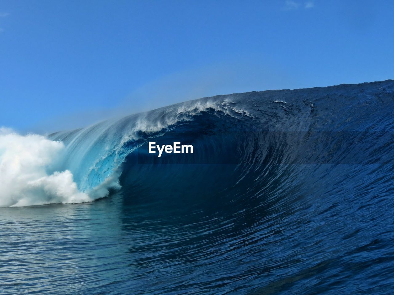 Scenic view of sea waves against clear blue sky