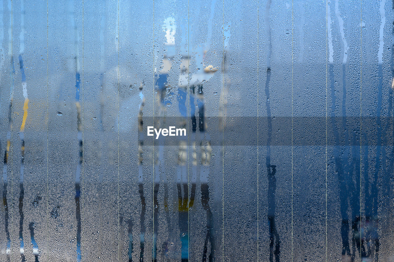 FULL FRAME SHOT OF GLASS WINDOW AGAINST BLUE SKY