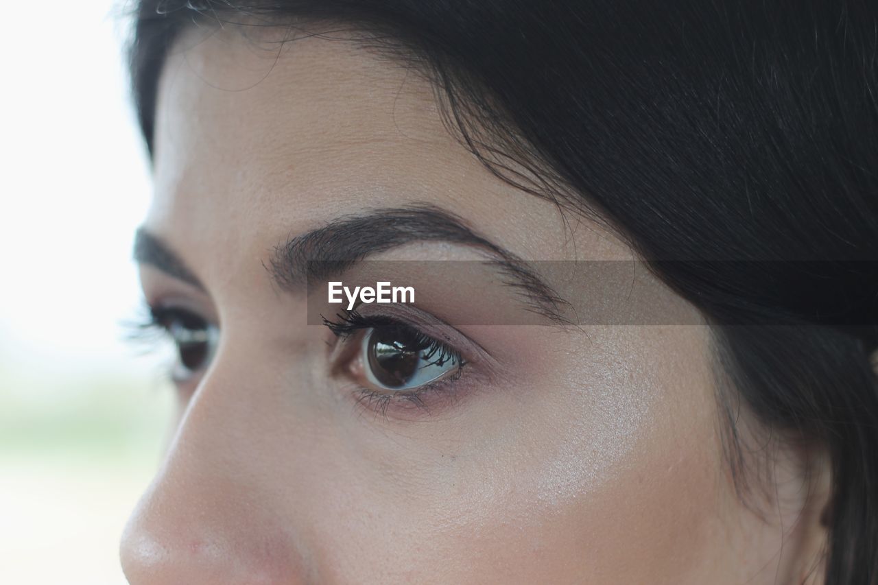 Cropped eyes of young woman looking away