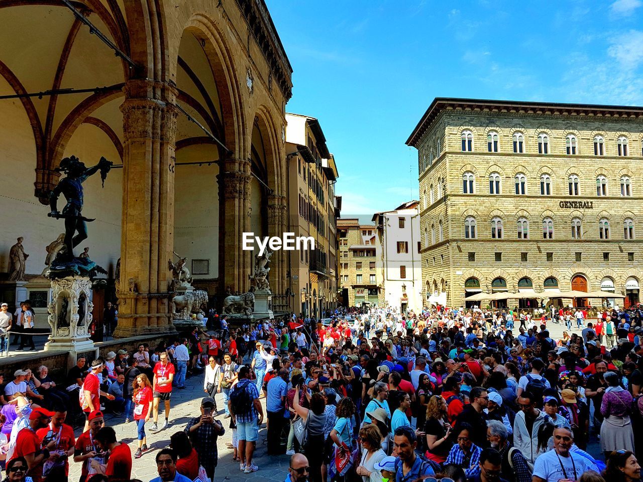 PEOPLE ON STREET AGAINST BUILDINGS