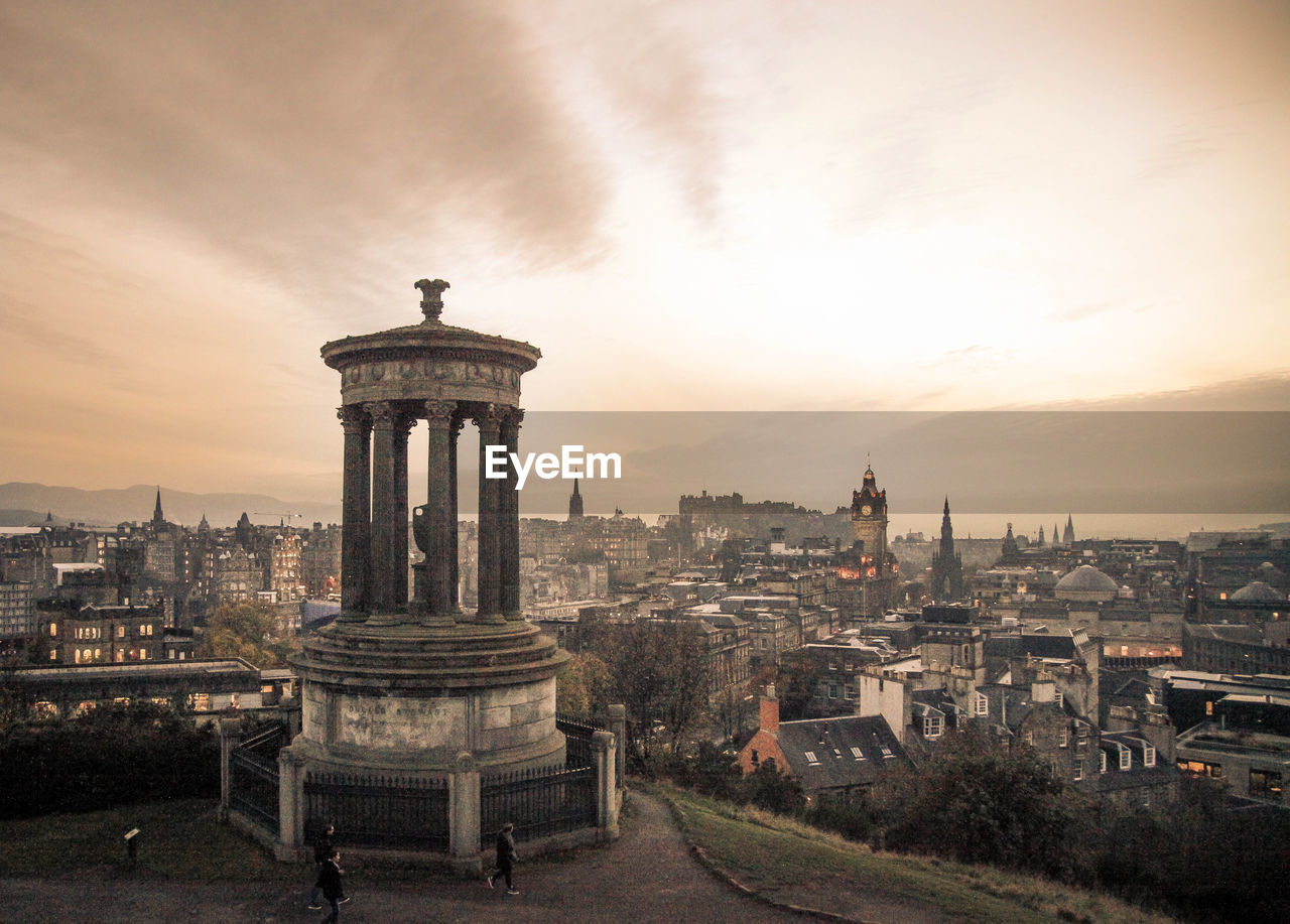 Historic structure overlooking cityscape against cloudy sky