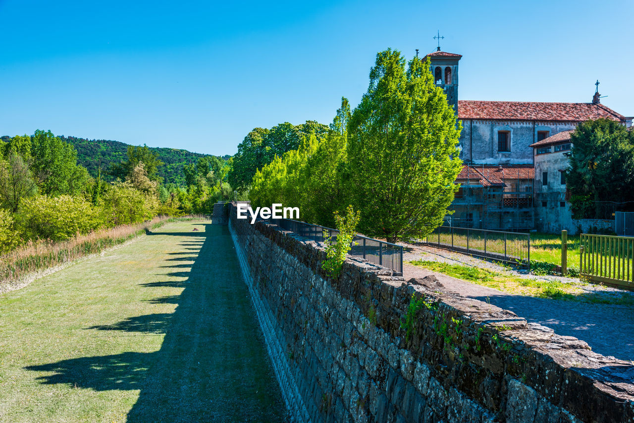 ROAD BY CANAL AGAINST CLEAR SKY