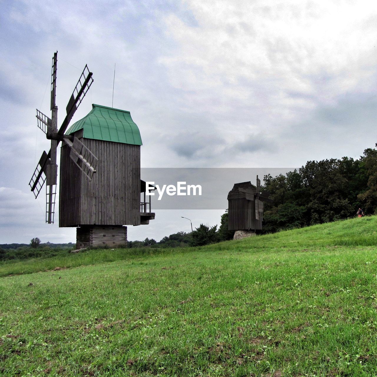 TRADITIONAL WINDMILL IN FARM AGAINST SKY