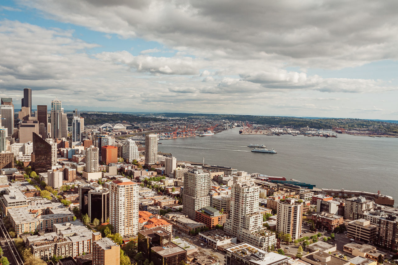 High angle view of buildings by sea against sky