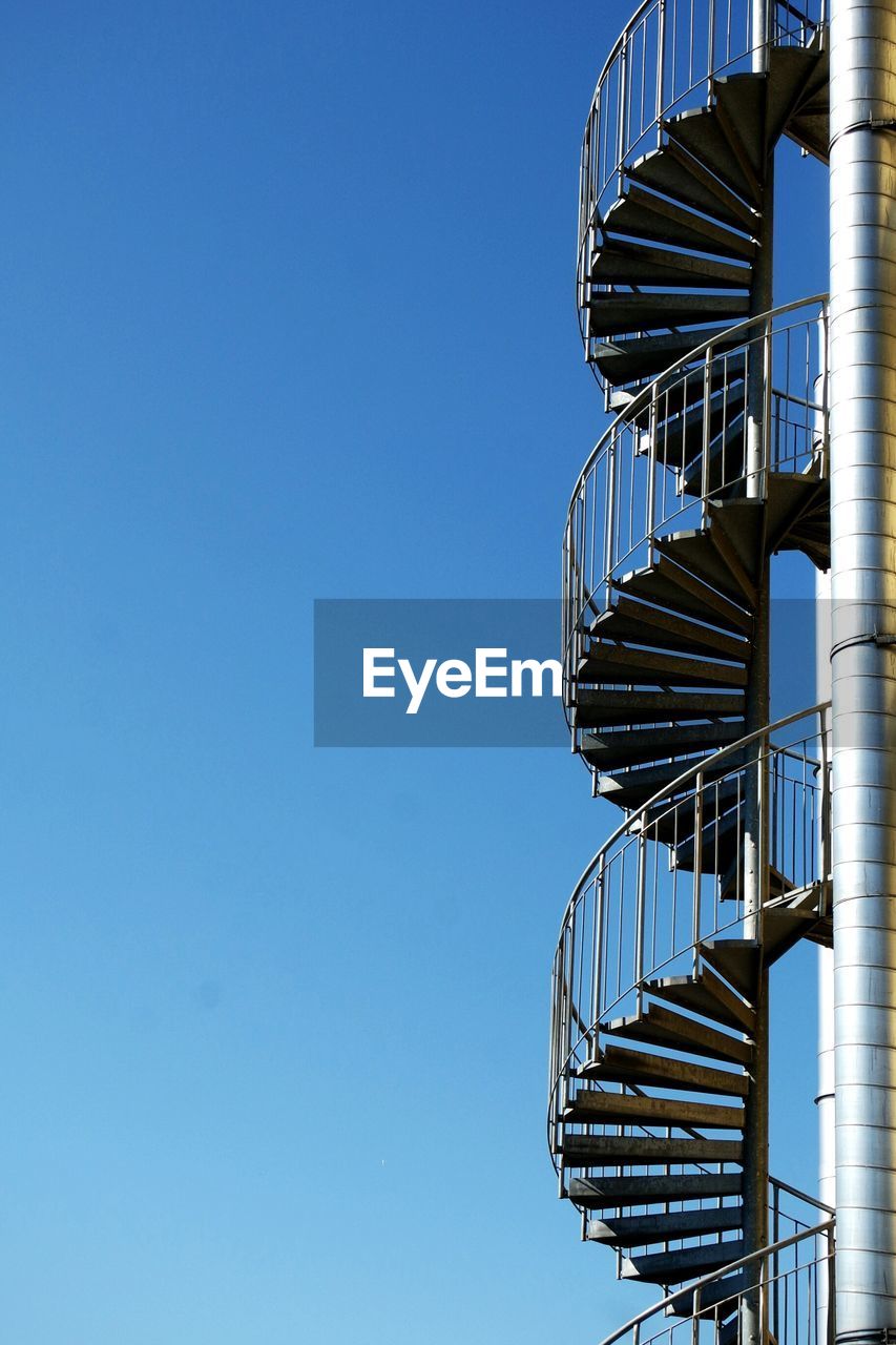 Low angle view of fire escape against clear blue sky