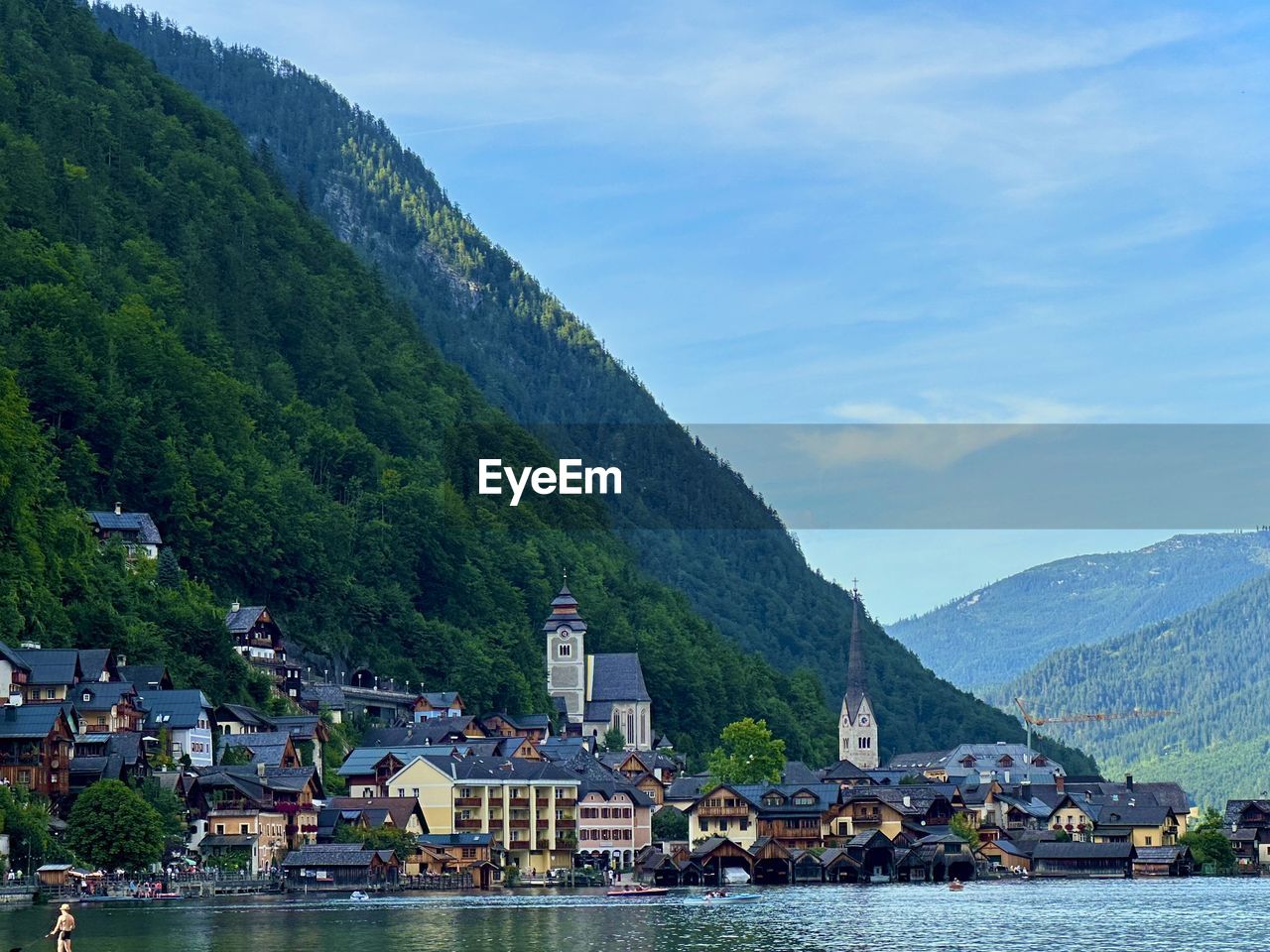 scenic view of townscape by mountains against sky