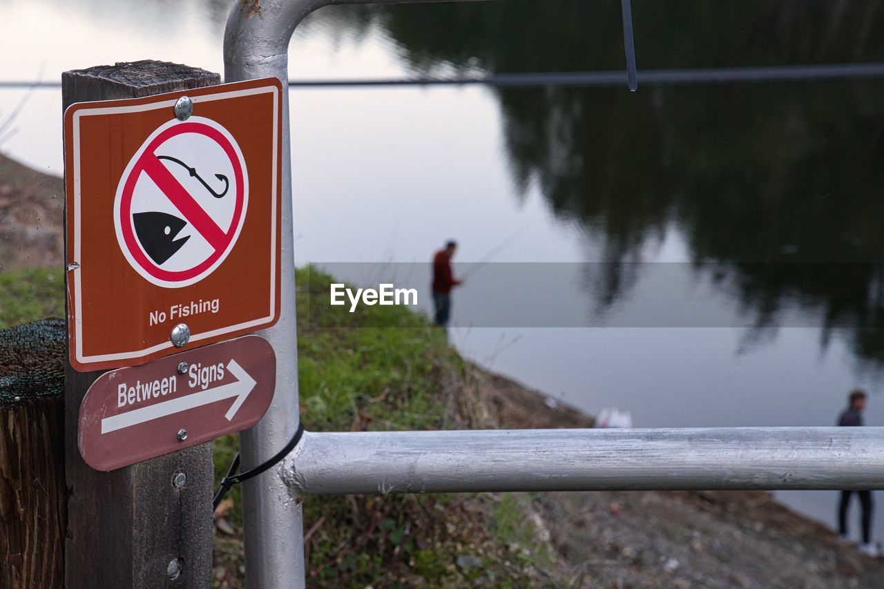 CLOSE-UP OF SIGN BY RAILING