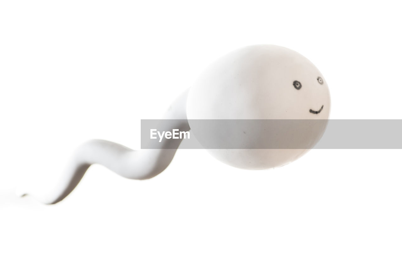 Digital composite image of sperm against white background