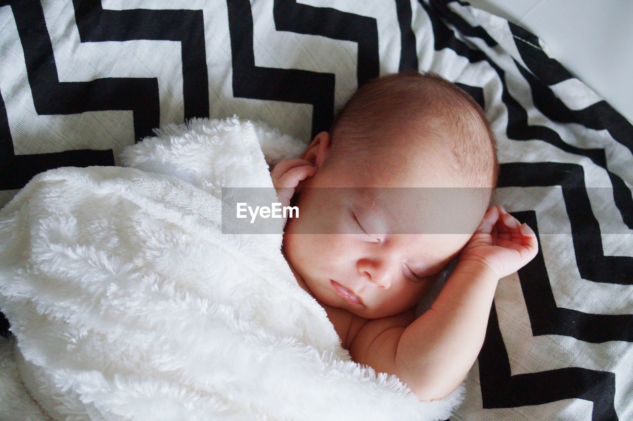 Close-up of baby sleeping on bed