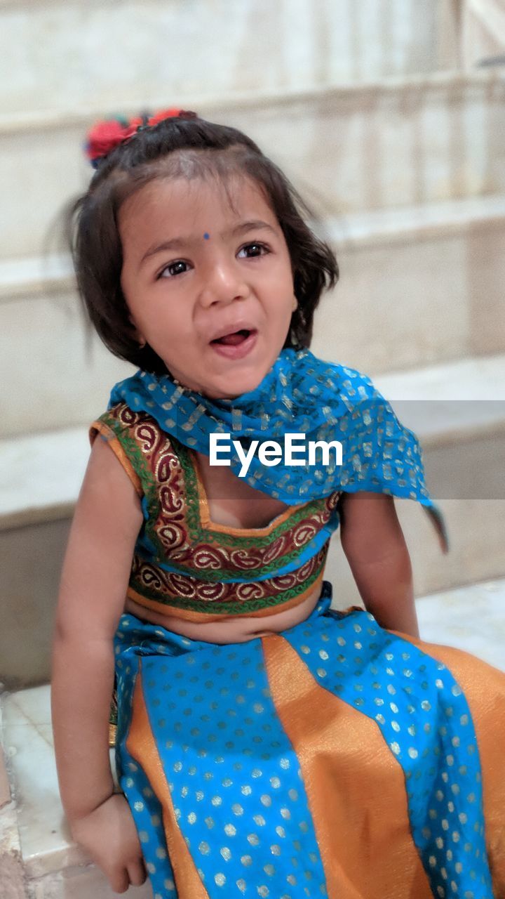 Close-up of girl looking away while sitting on steps