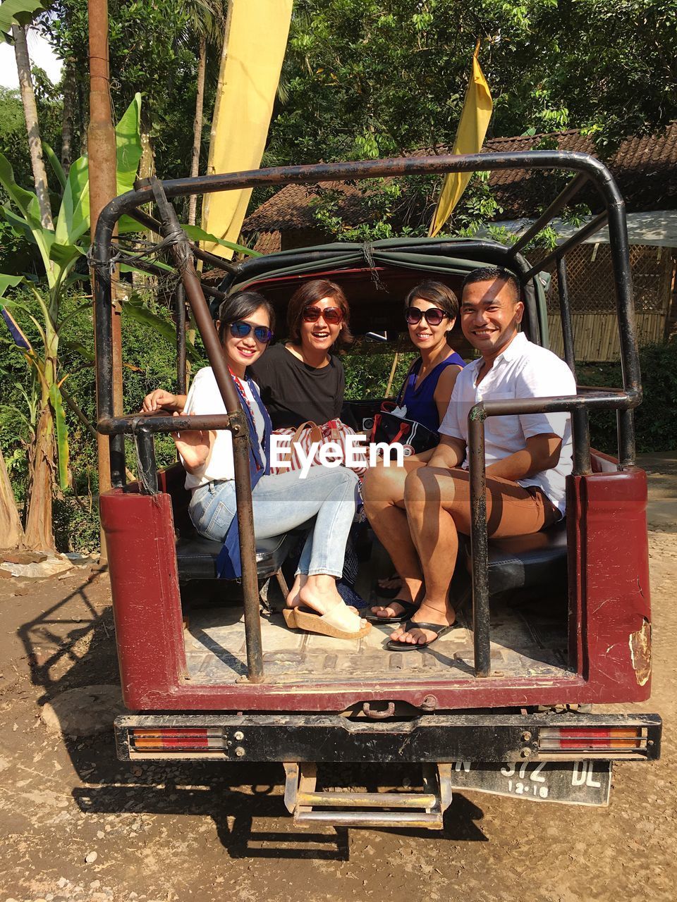 Portrait of happy friends sitting in off-road vehicle