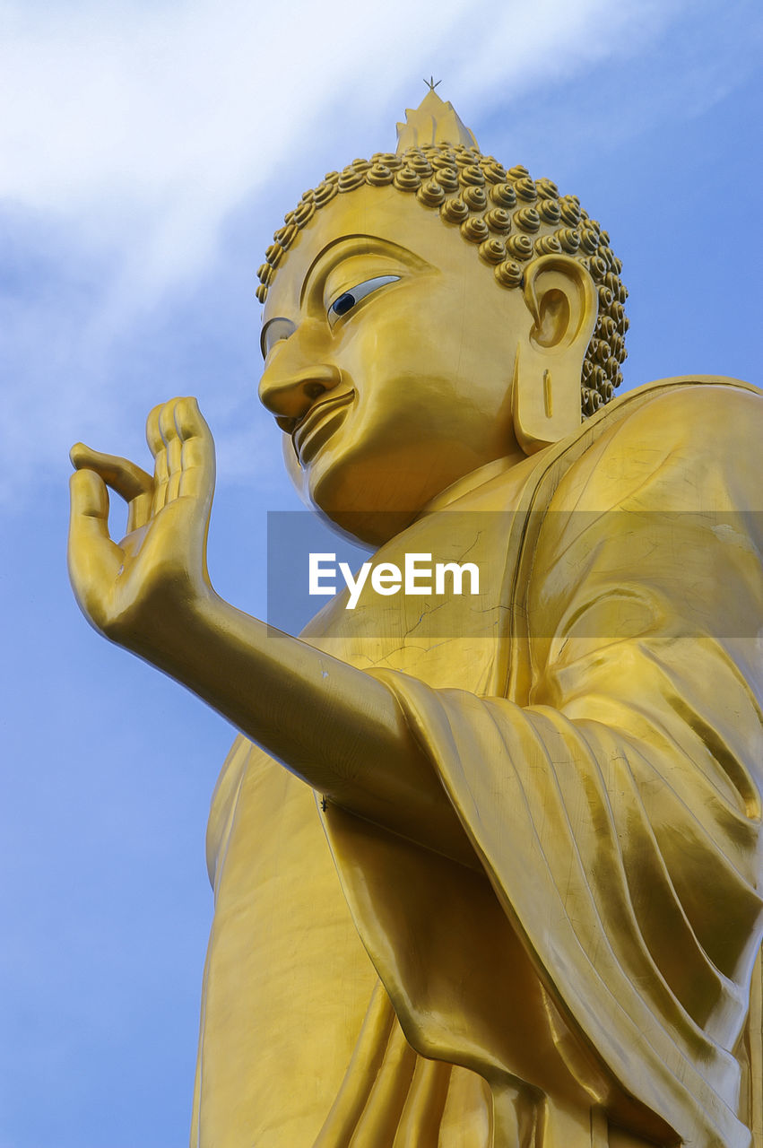 Low angle view of buddha statue against sky