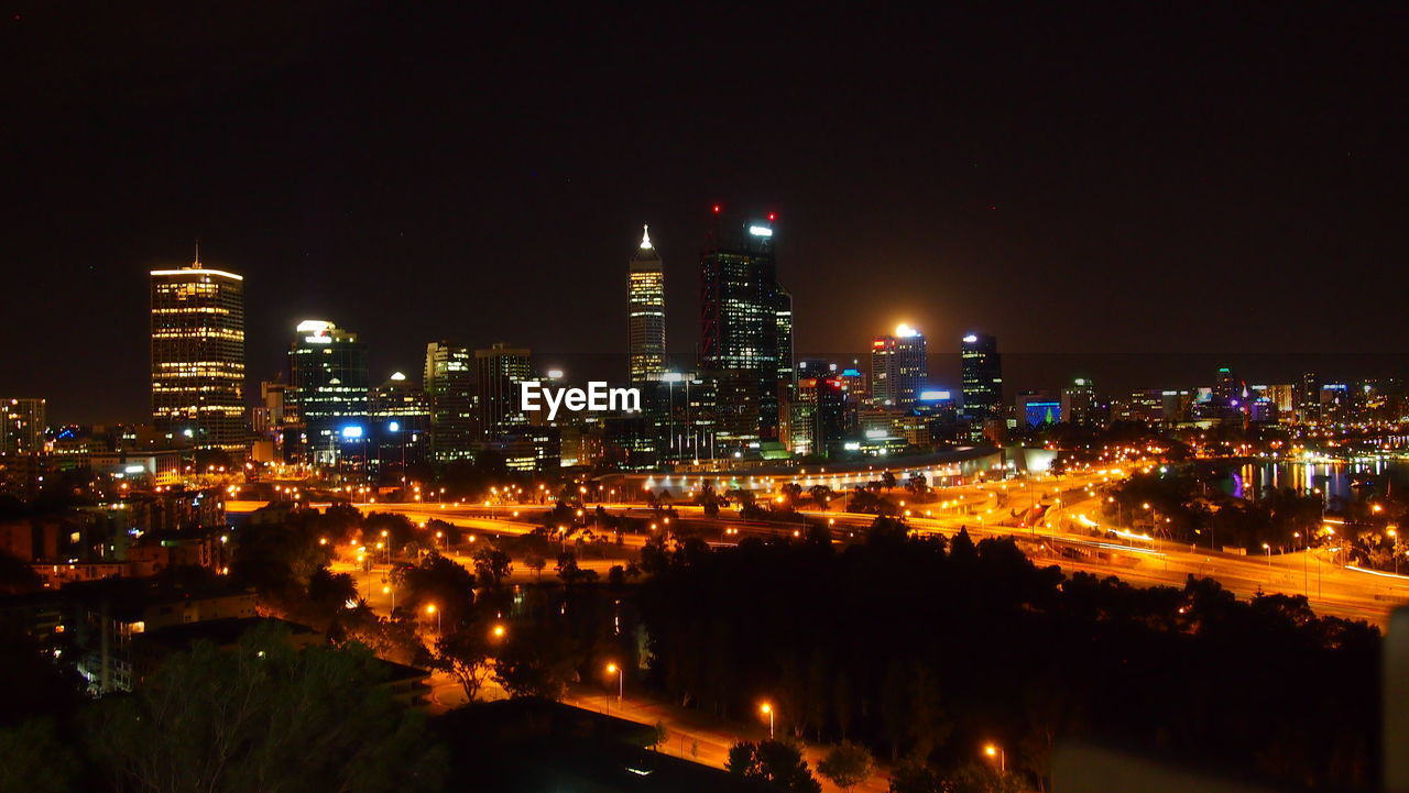 HIGH ANGLE VIEW OF ILLUMINATED BUILDINGS AT NIGHT