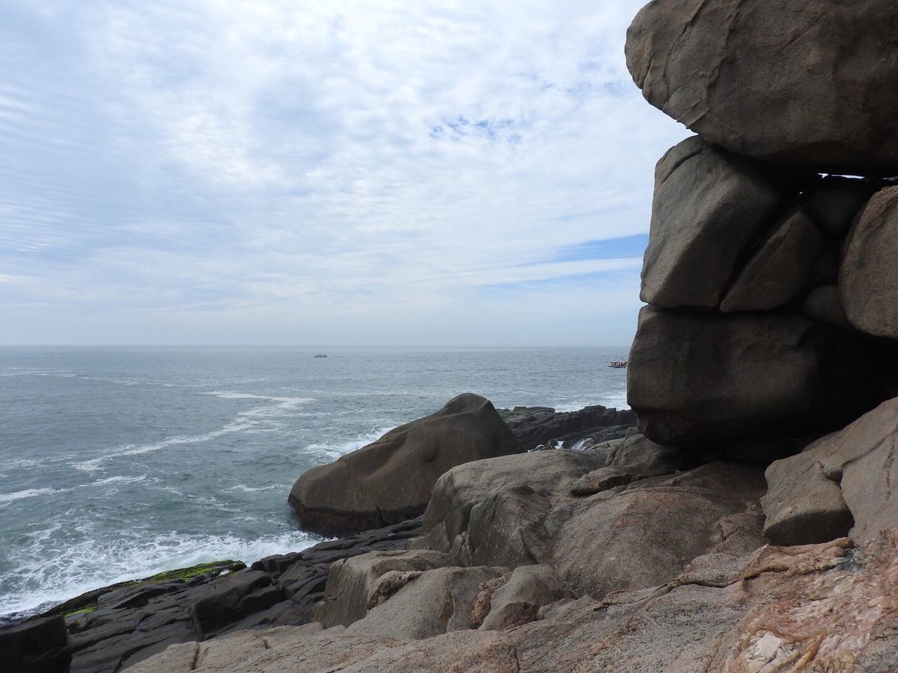 Rocks at sea shore against sky