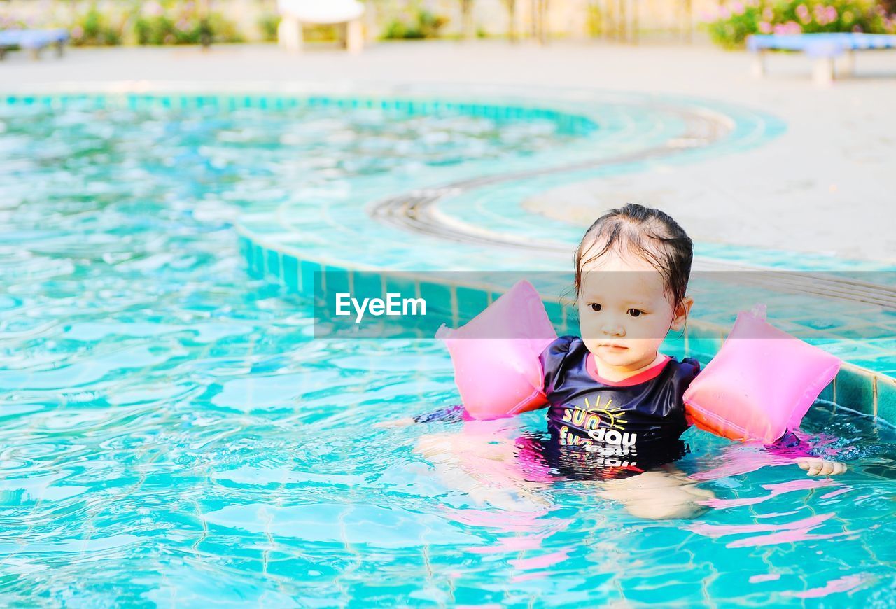 PORTRAIT OF A BOY SWIMMING IN POOL