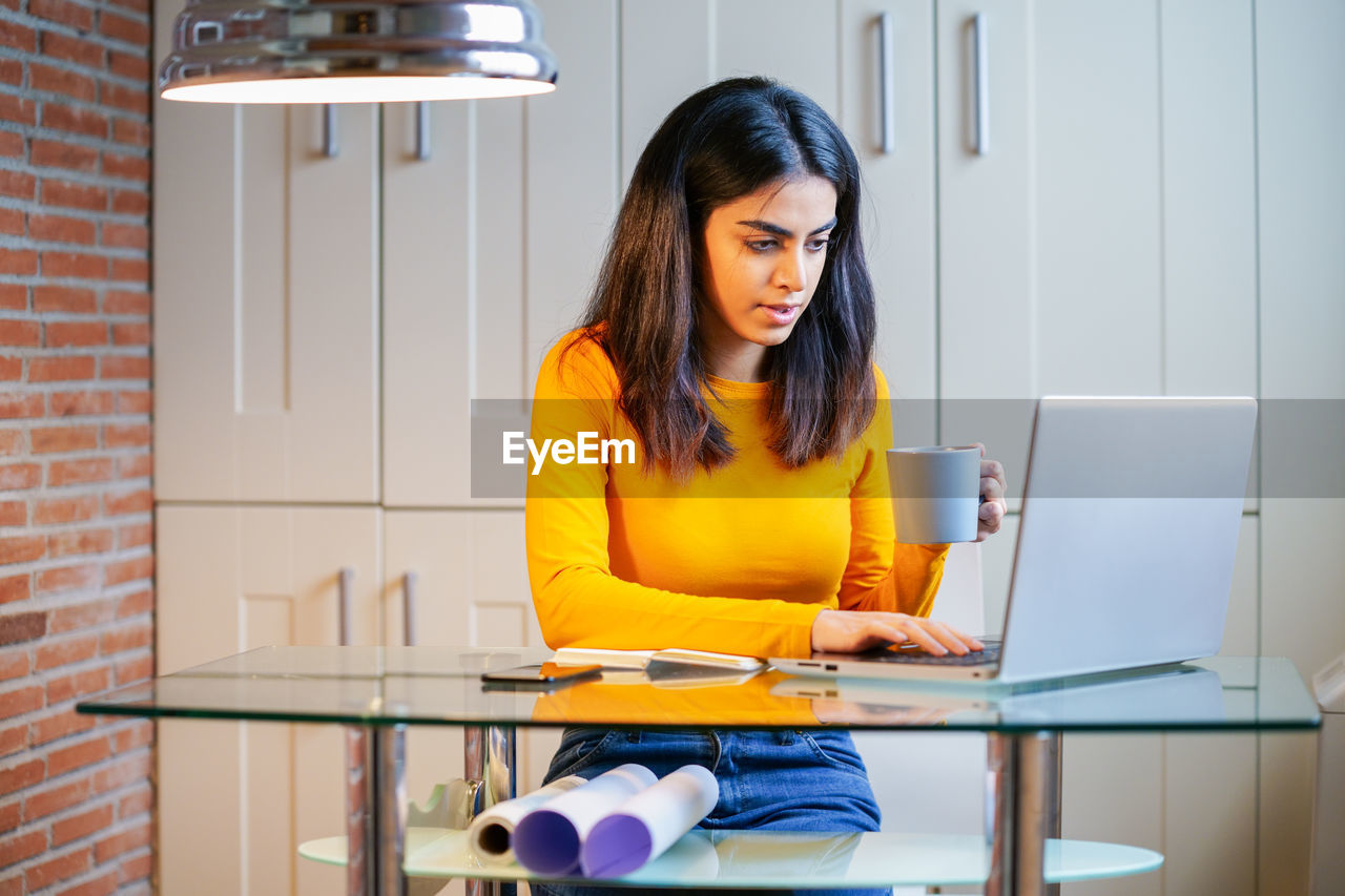 Businesswoman using laptop on desk in office