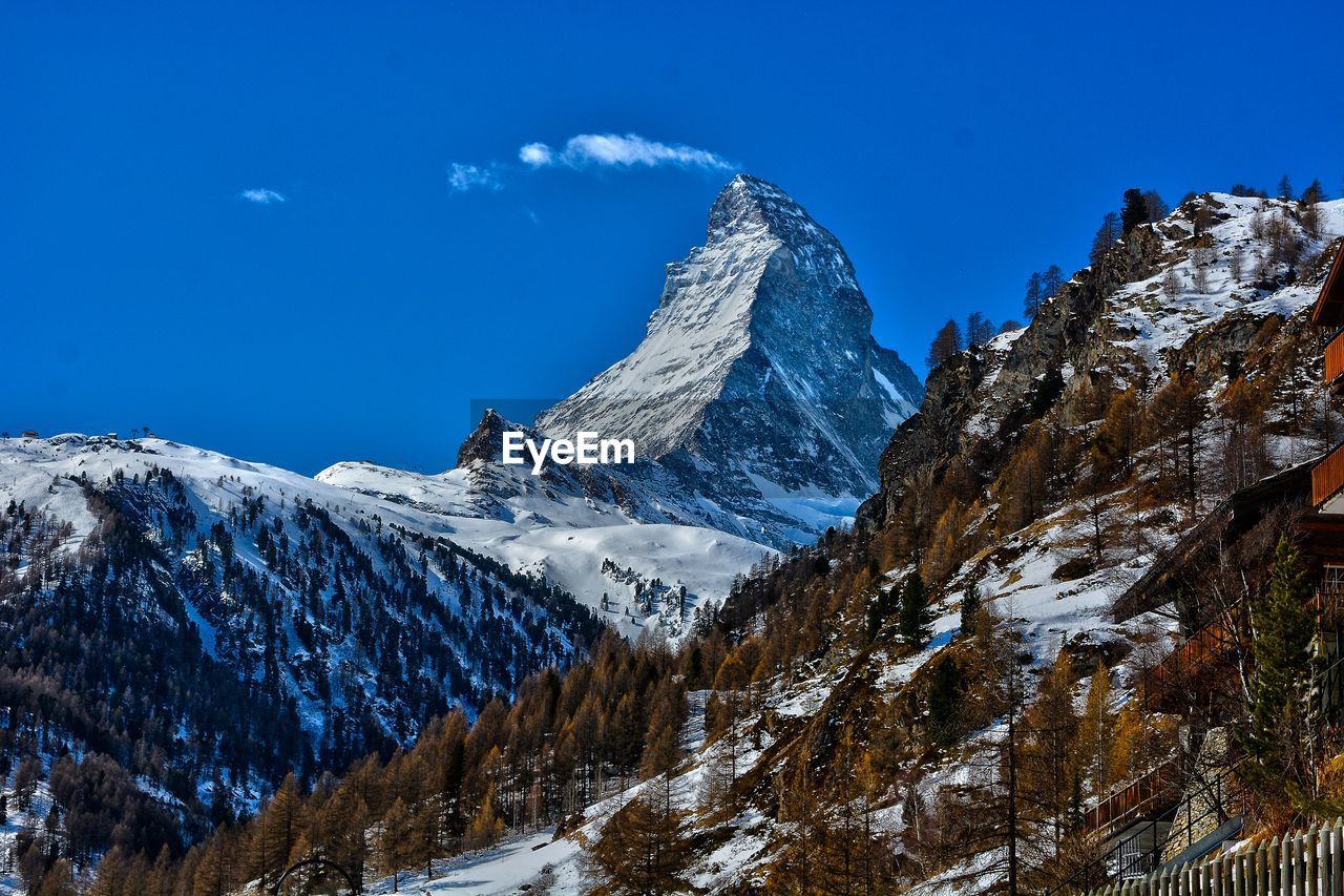 Zermatt scenic view of snowcapped mountains against blue sky
